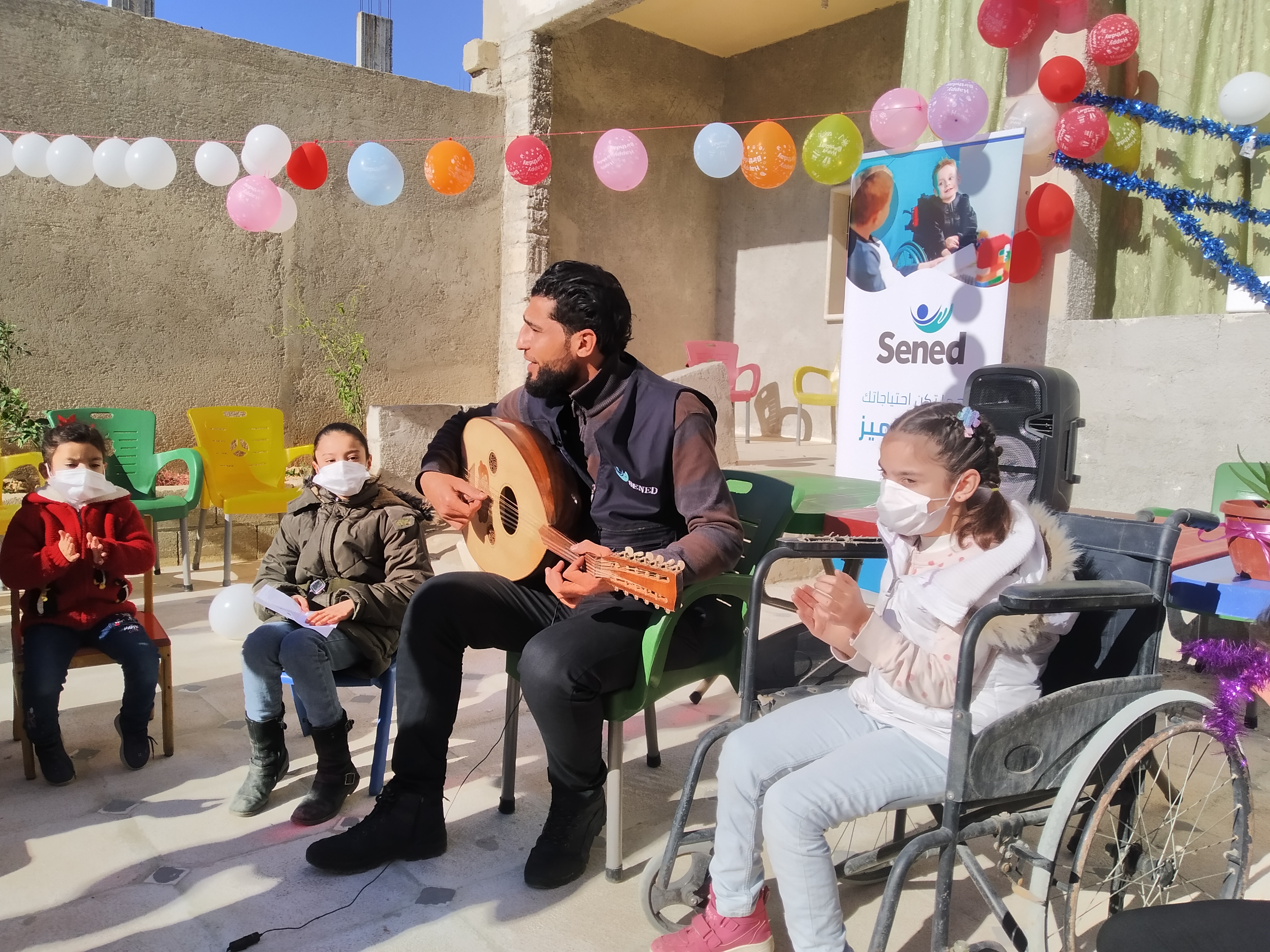 A group of children sit in a circle in an inclusive music therapy class led by Make Music Matter.
